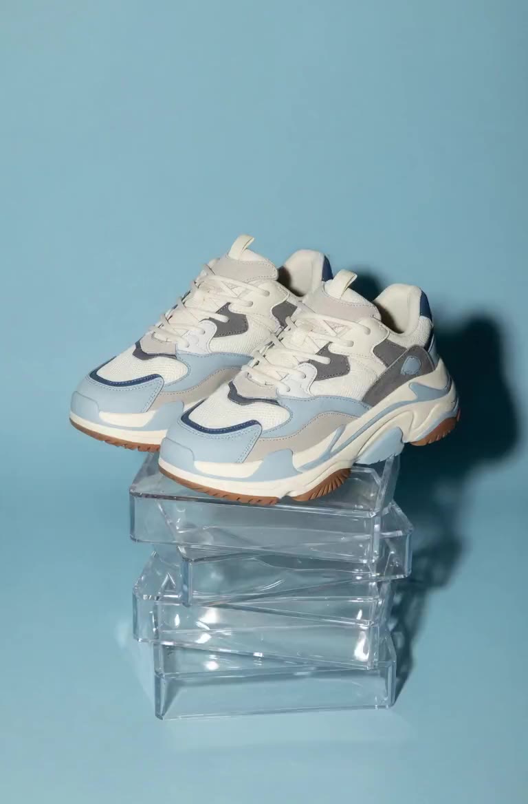 Kiosko, zapatillas girando sobre un pedestal acrílico