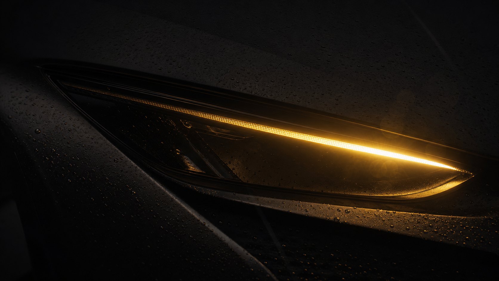 Macro of the NOCTIS GT headlamp, the Signature, a single unbroken line of amber light set into matte black bodywork.